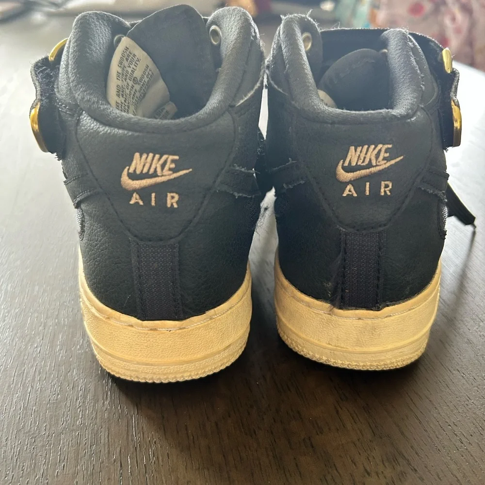 Nike Air Force ones black high top sneakers gold trim